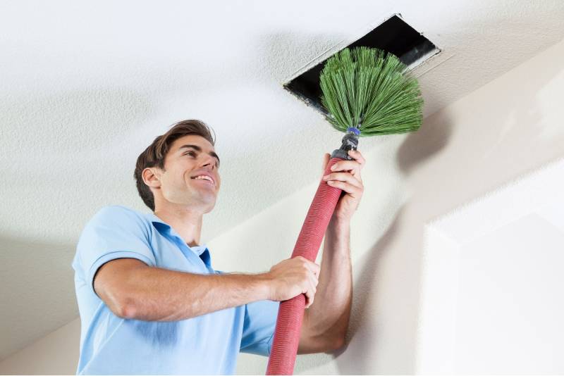 Technician cleaning an air vent